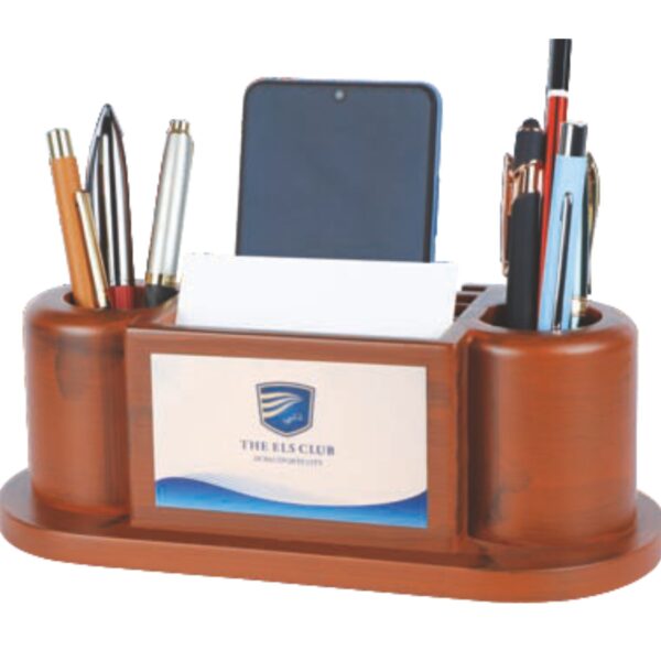 A robust, traditional organizer with a warm brown wood-finish. It features two large, rounded pen pot holders on the sides, separated by a central section with a phone/card slot. The large, framed space in the middle provides maximum area for branding. Category: Table Top, Home & Living Branding Options: Logo on planter, Branded packaging sleeve. Lead Time: 10-14 business days.